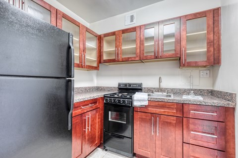 a kitchen with wood cabinets and a black stove and refrigerator